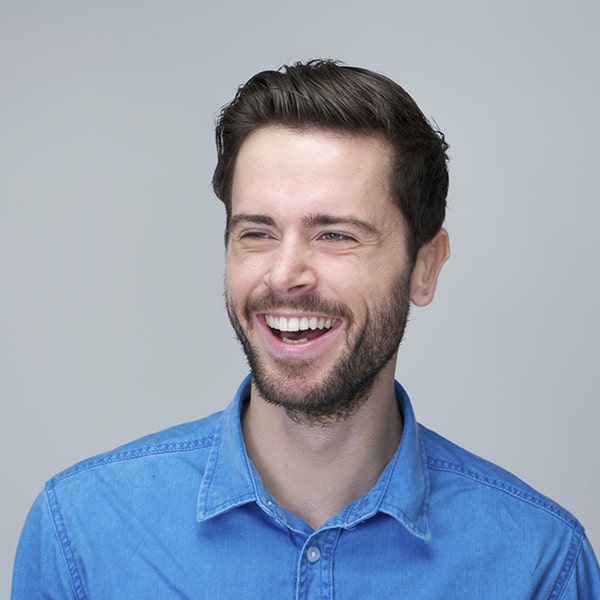 a man wearing a blue collar polo  with a beard and mustache having  a big laugh 